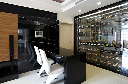 电器柜台面和上方挑空的位置皆选用黑色烤漆玻璃,在深度不一的立面