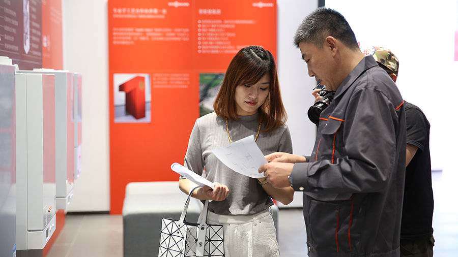 设计师陈燕燕与菲斯曼员工沟通设计安装方案